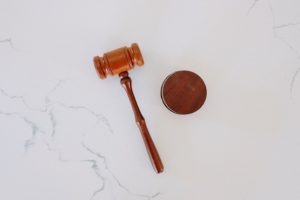 Wooden judge’s gavel and sound block on a white marble surface