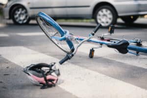 Bike crashes involving a fallen bicycle and helmet after a collision, showing the risk of head injury to cyclists