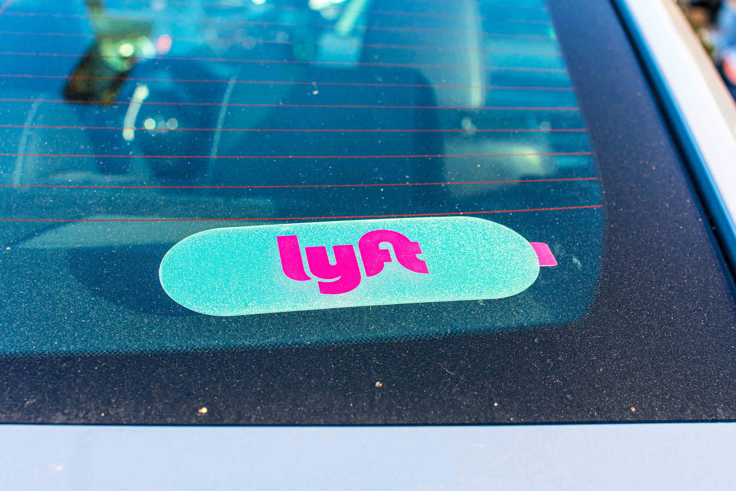 Lyft sticker on car window represented by Fort Worth Lyft accident lawyers.