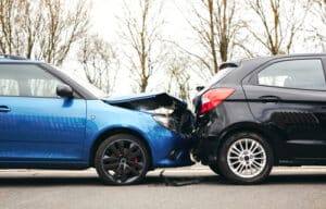 Dallas car accident lawyer reviewing rear-end collision crash scene between two vehicles on a city street.