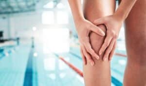 Swimming pool accident in Dallas showing person holding injured knee near pool area with a San Antonio premises liability attorney context.