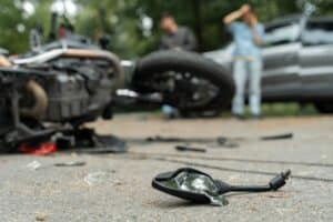 Dallas motorcycle accident lawyer highlighting crash scene with damaged motorcycle and broken mirror on roadway.