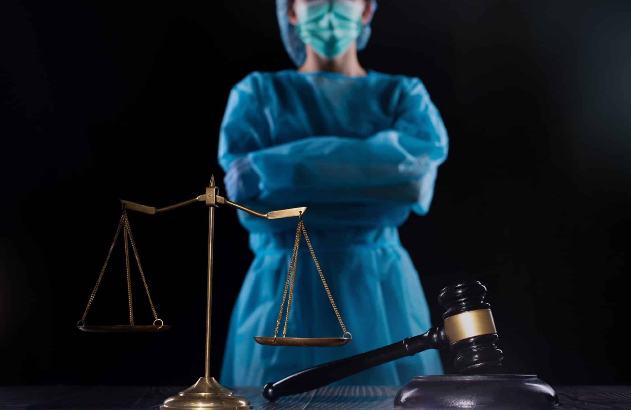 A medical professional standing behind a gavel and scales of justice, symbolizing medical negligence and legal accountability.